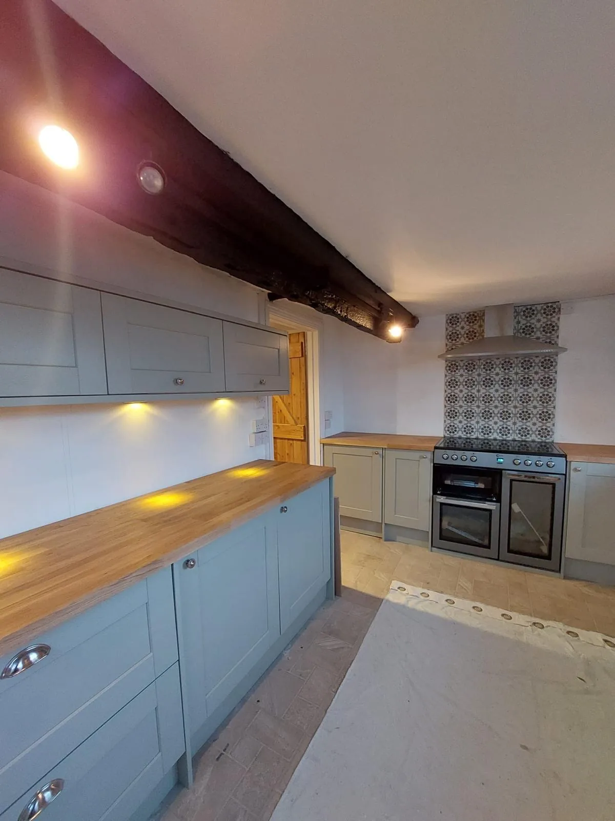 Completed kitchen showing the exposed beam and under-cabinet lighting
